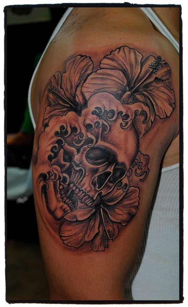 Check out this awesome black and grey skull and flowers tattoo